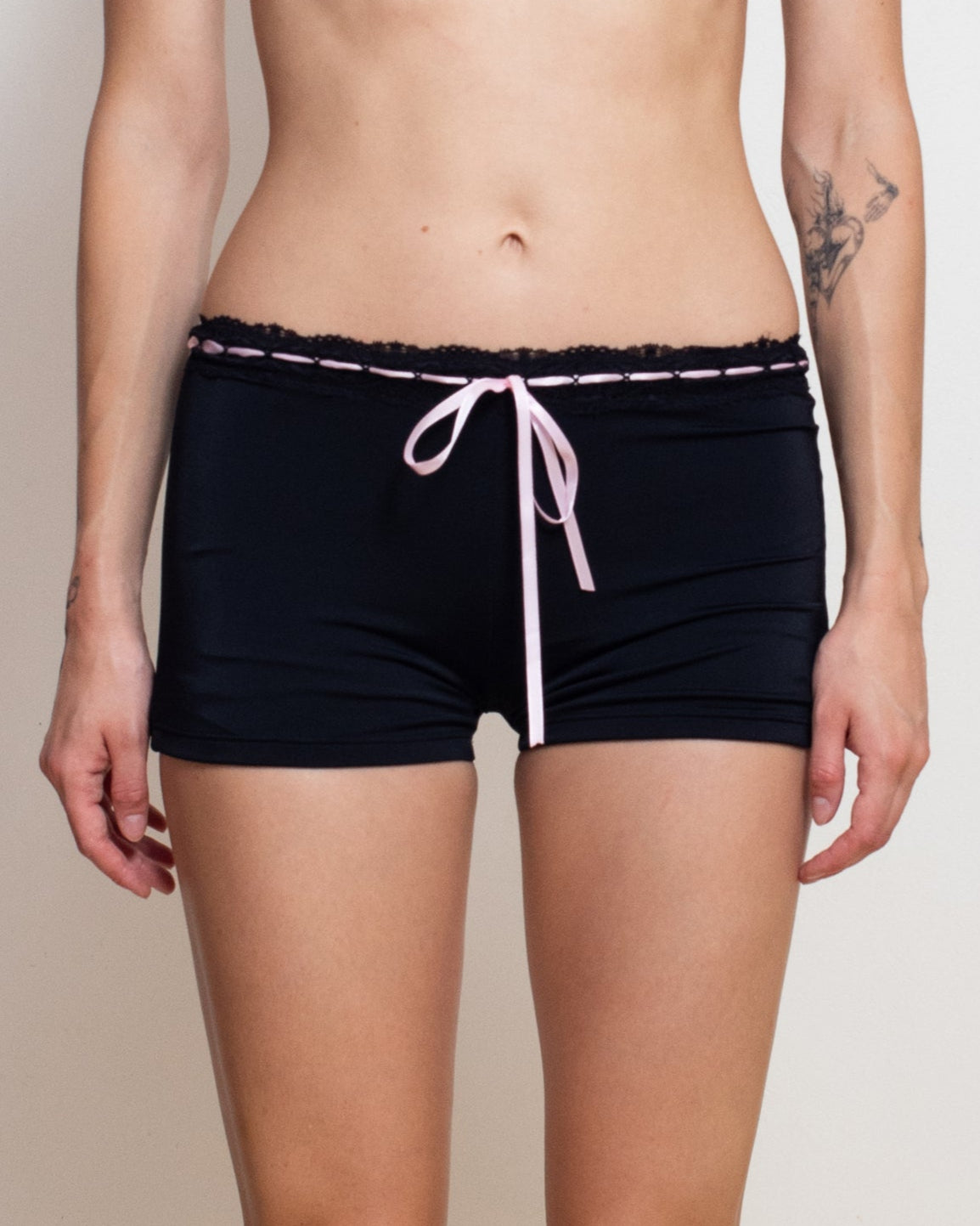 Woman wearing a black bikini with white trim against a plain background