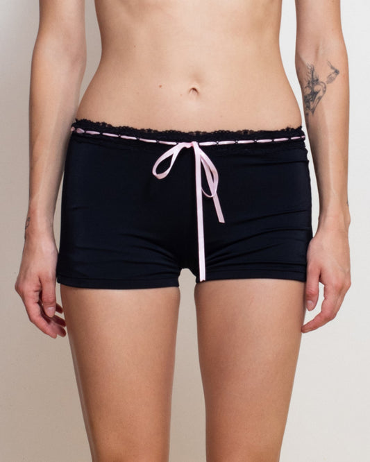 Woman wearing a black bikini with white trim against a plain background