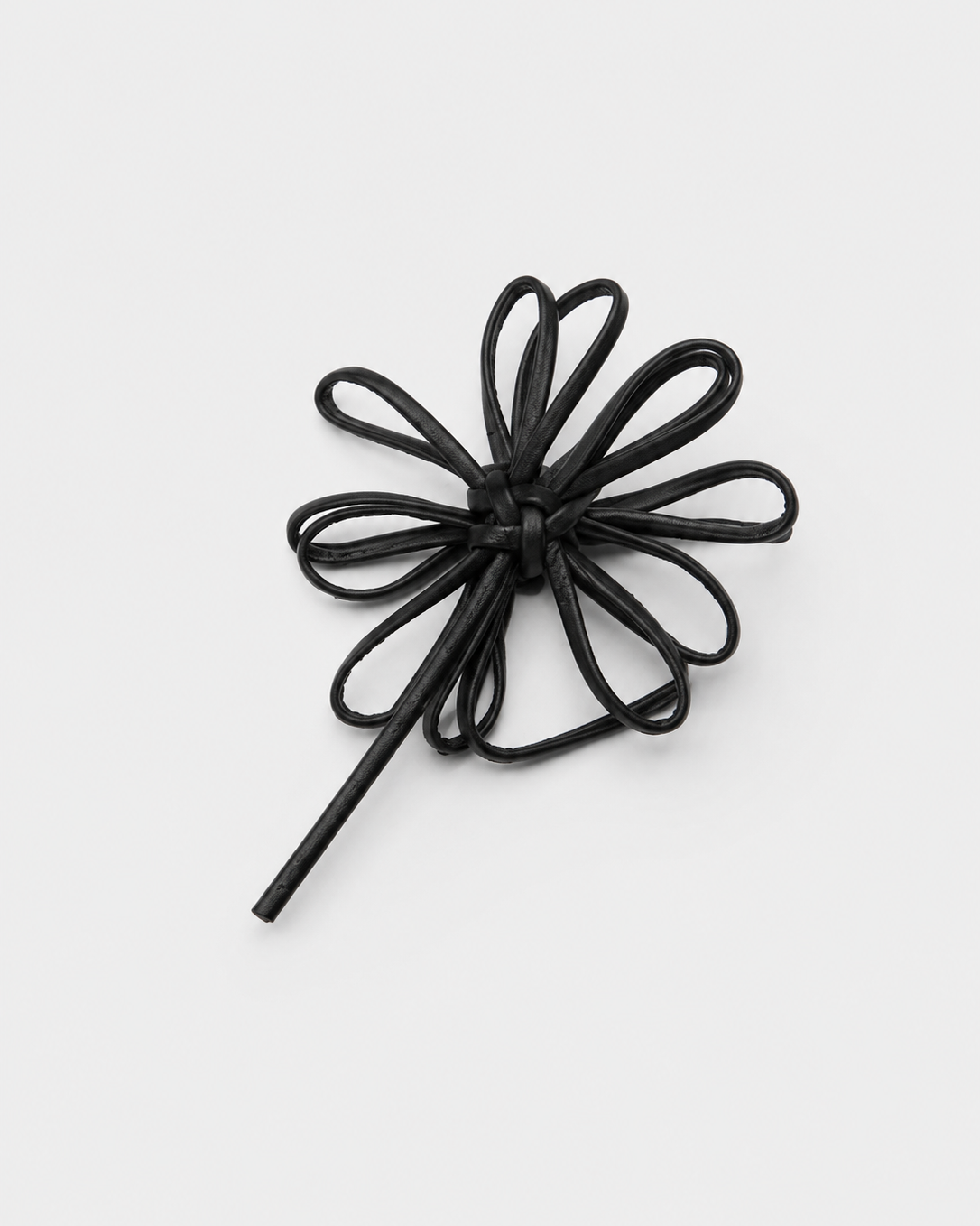 Black hair tie shaped like a flower on a white background