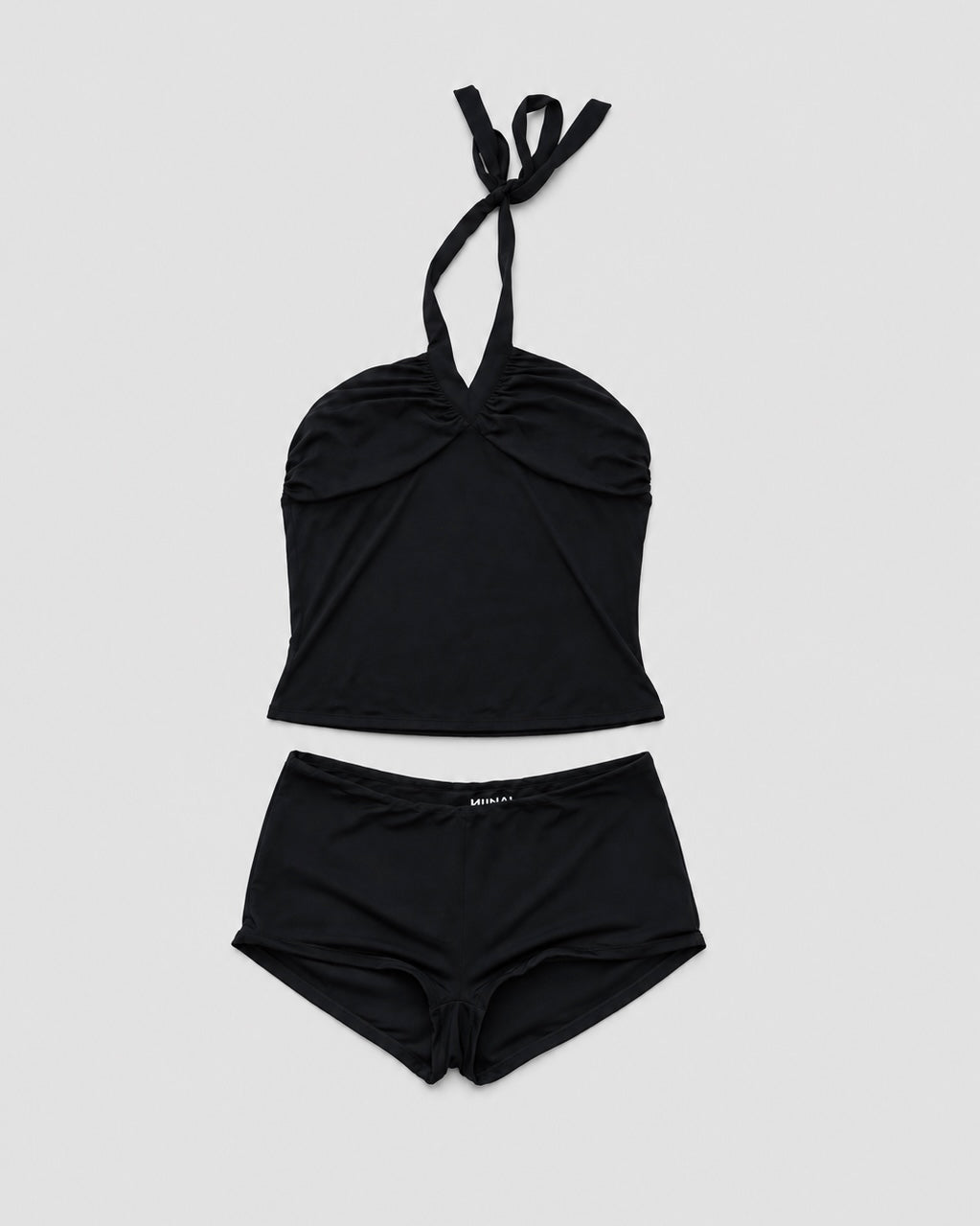 Black halter top with tie straps on a light gray background