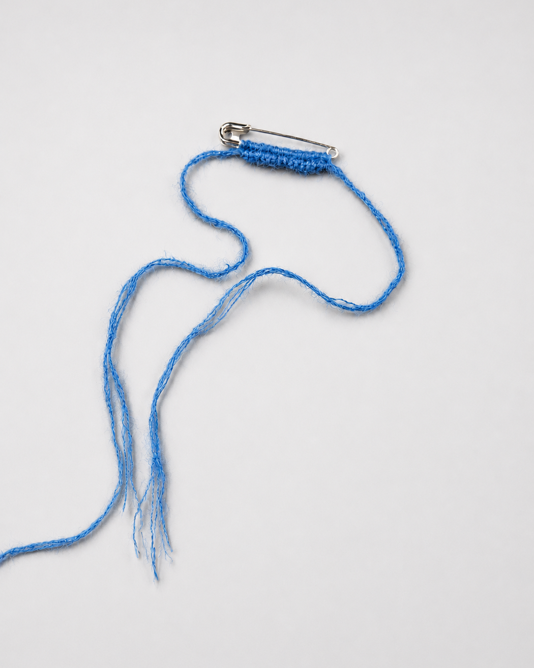 Blue braided lanyard with a metal clip on a white background