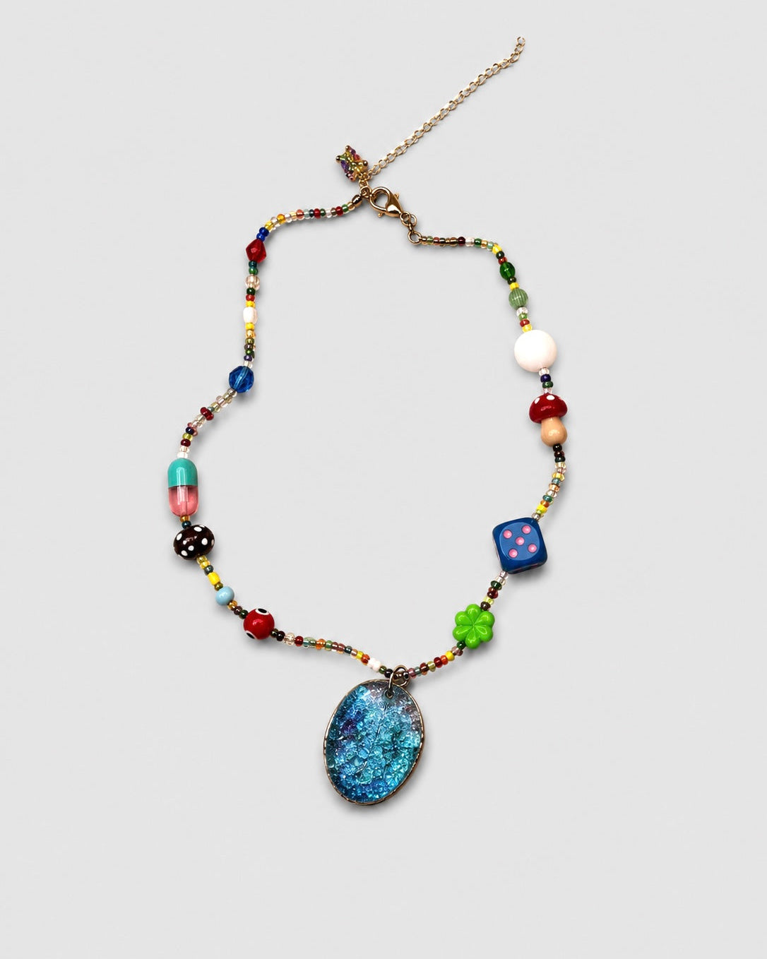 Colorful beaded necklace with a blue pendant on a light gray background