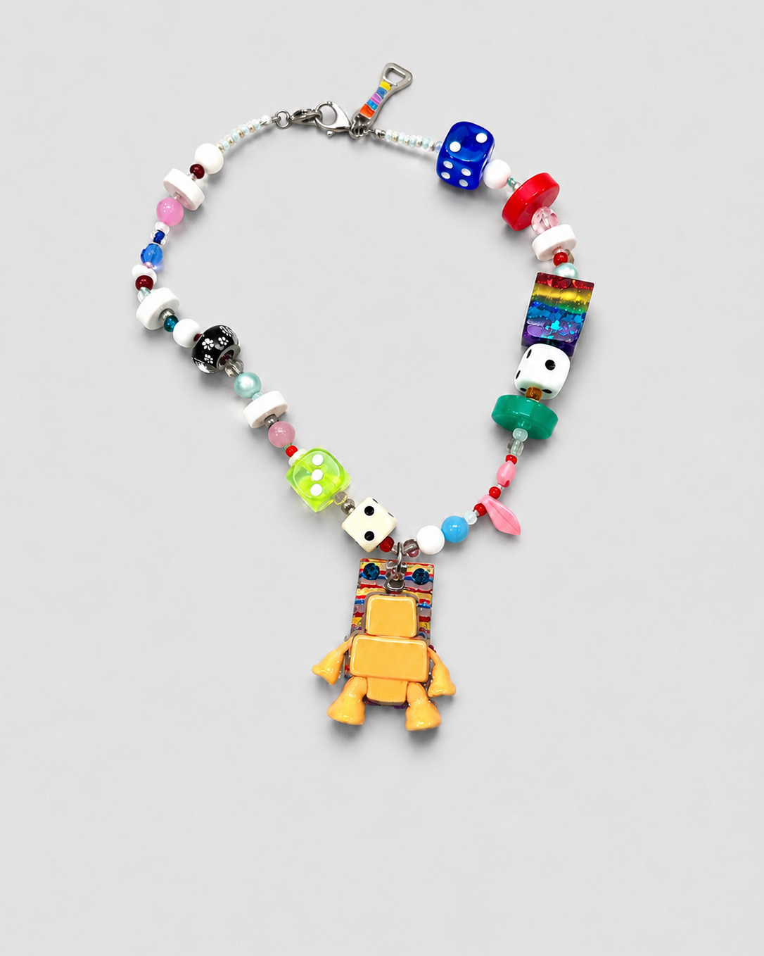 Colorful beaded necklace with a yellow turtle pendant on a light gray background