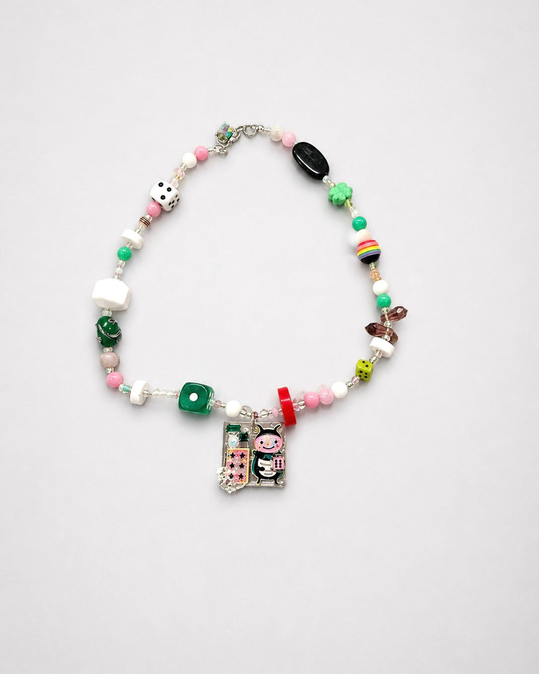 Colorful beaded necklace with various charms on a light gray background