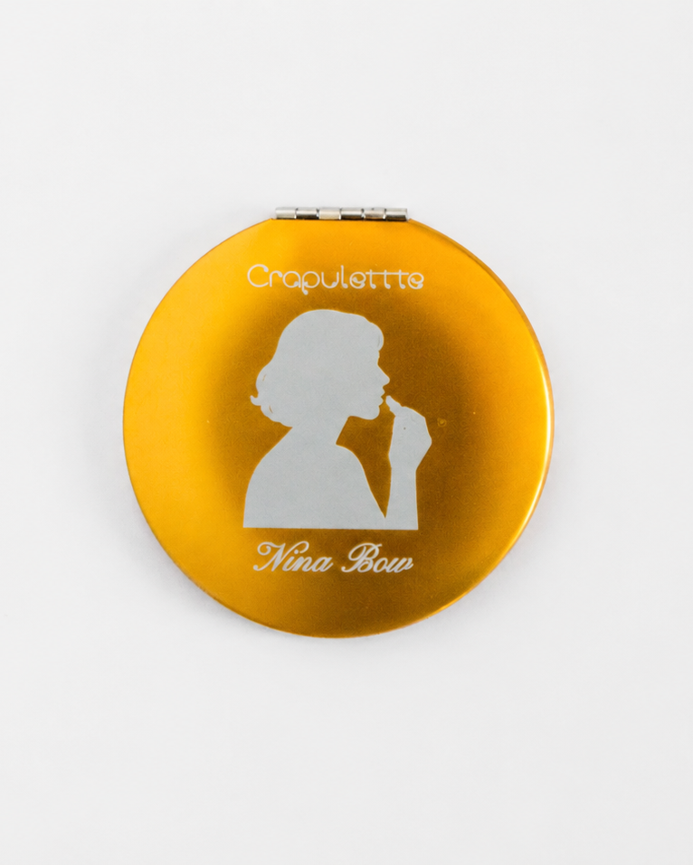 Compact mirror with a yellow casing and white silhouette design on a white background