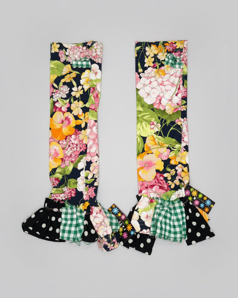 Floral patterned leg warmers with ruffles on a gray background
