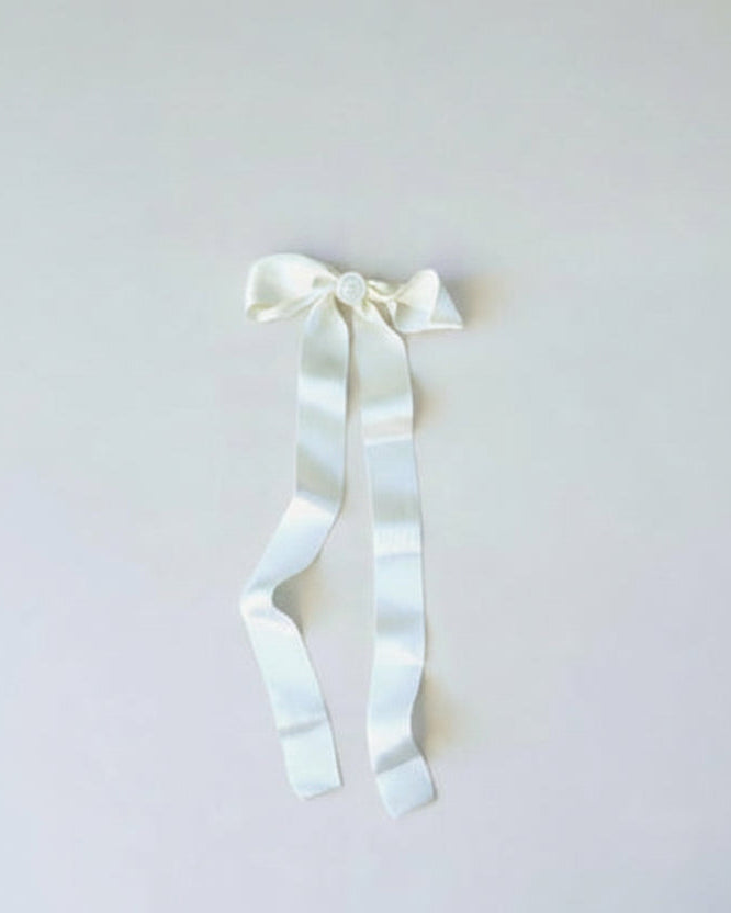 White ribbon with a bow on a light gray background