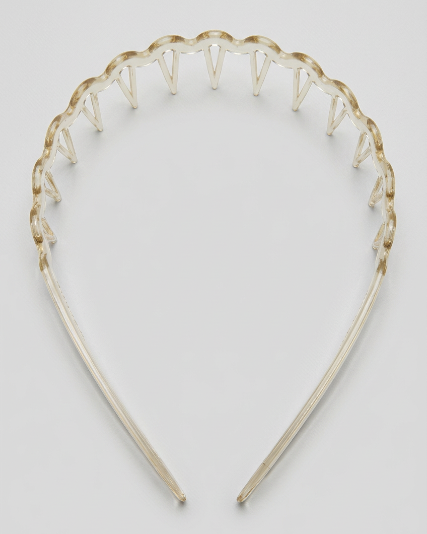 A clear headband with a scalloped, spiked top edge, photographed against a plain white background.