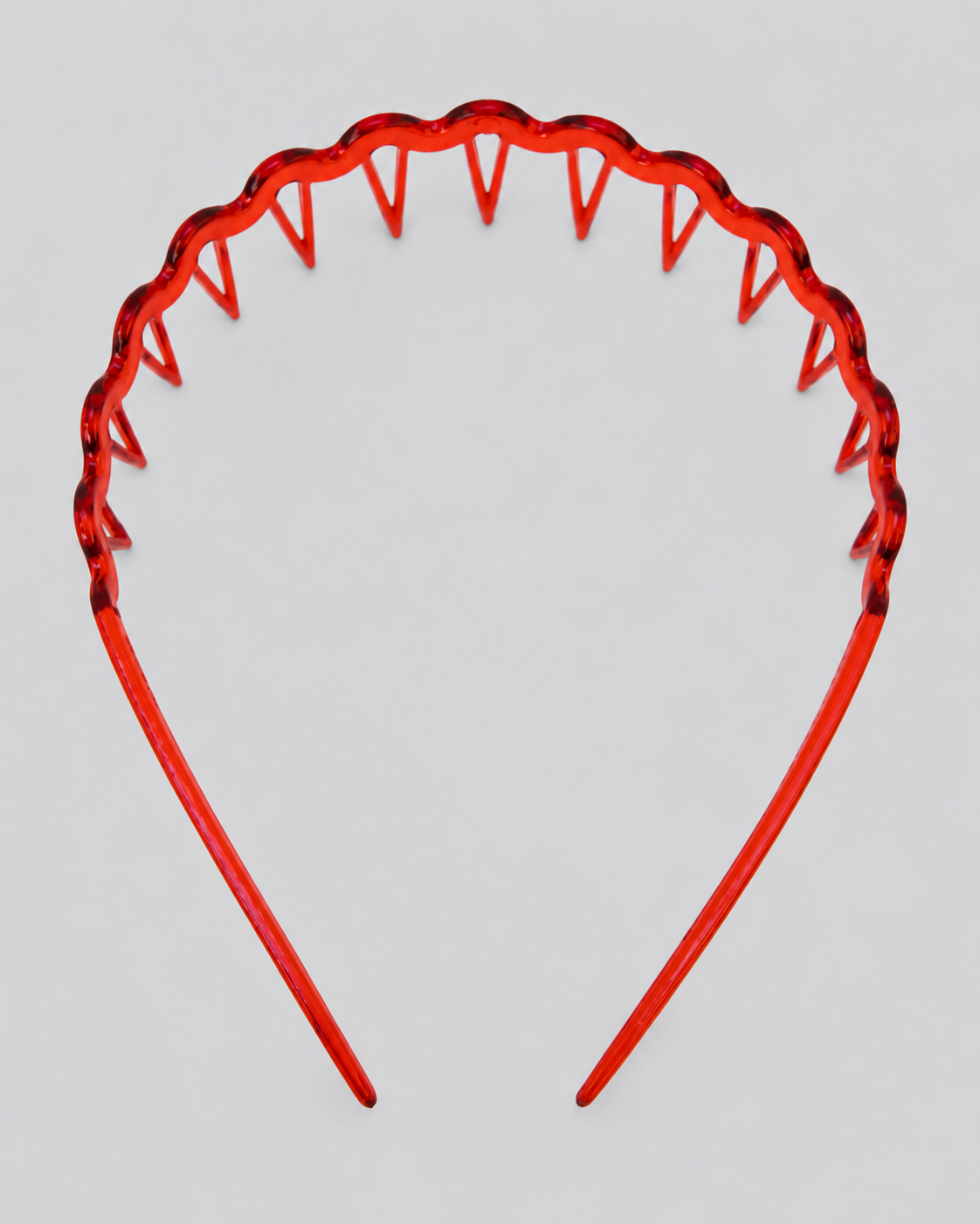 A translucent red headband with a wavy upper edge and sharp triangular teeth-like points along the top, shown against a plain light gray background.